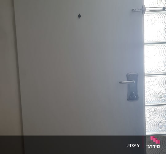 דלת עם ידית מתכת ליד חלון זכוכית מעוצב