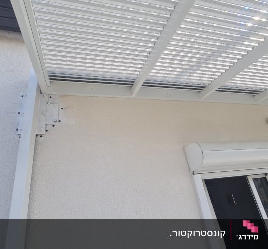 גג פרגולה מתכתית מחוברת לקיר עם ברגים