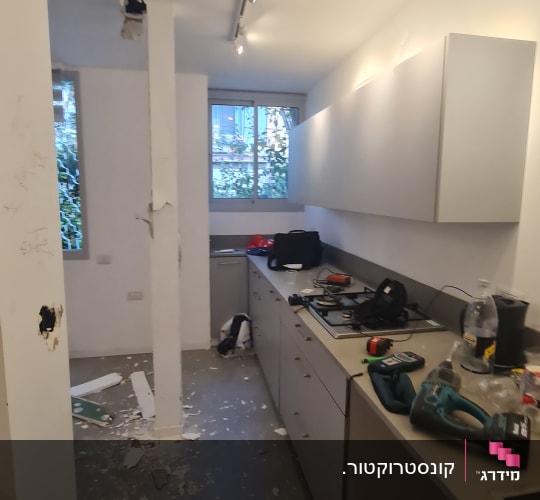 מטבח בשיפוץ עם כלים וחומרים על השיש