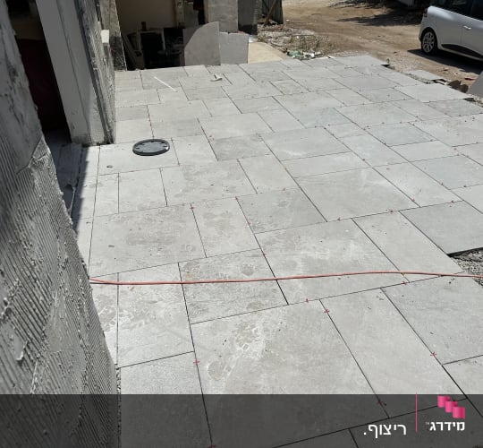 ריצוף חדש עם אריחים אפורים וחוט סימון אדום