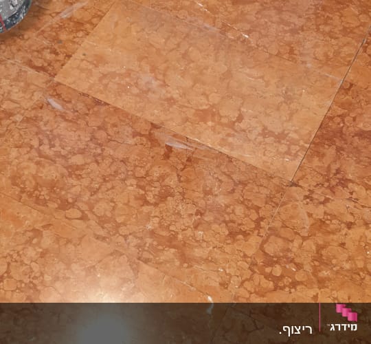רצפת שיש עם סימני שיפוץ וכתמי צבע