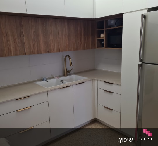 מטבח משופץ עם ארונות לבנים וברז זהב