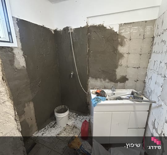 חדר אמבטיה בשיפוץ עם כיור וחומרים