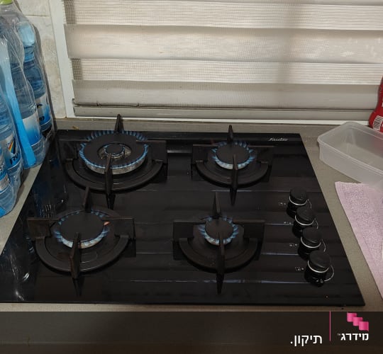 כיריים גז עם ארבעה מבערים דולקים במטבח