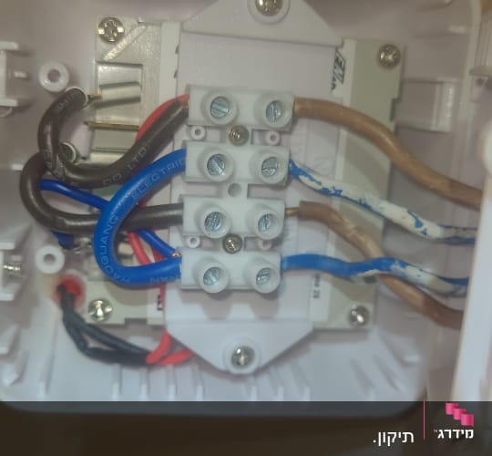 חיבורים חשמליים בתוך קופסה לבנה עם חוטים צבעוניים