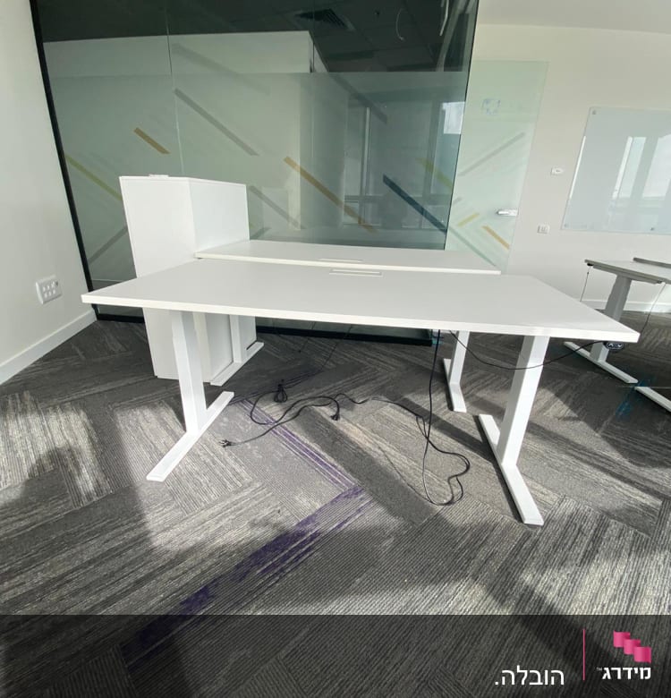 שולחן לבן עם כבלים על רצפה אפורה