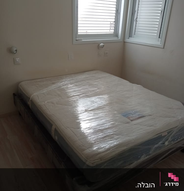 מזרן עטוף בניילון מוכן להובלה בחדר ריק