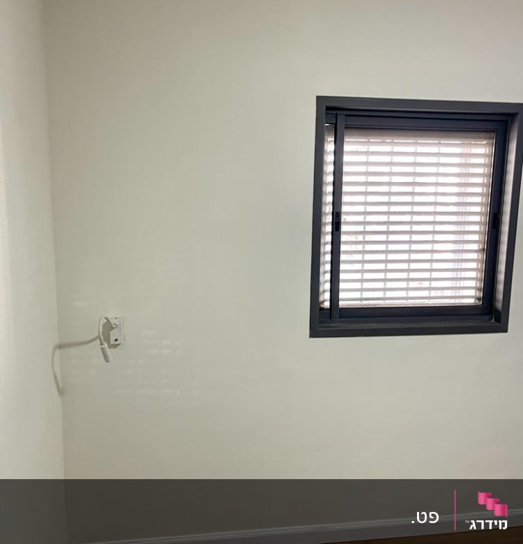 קיר צבוע בלבן עם חלון קטן