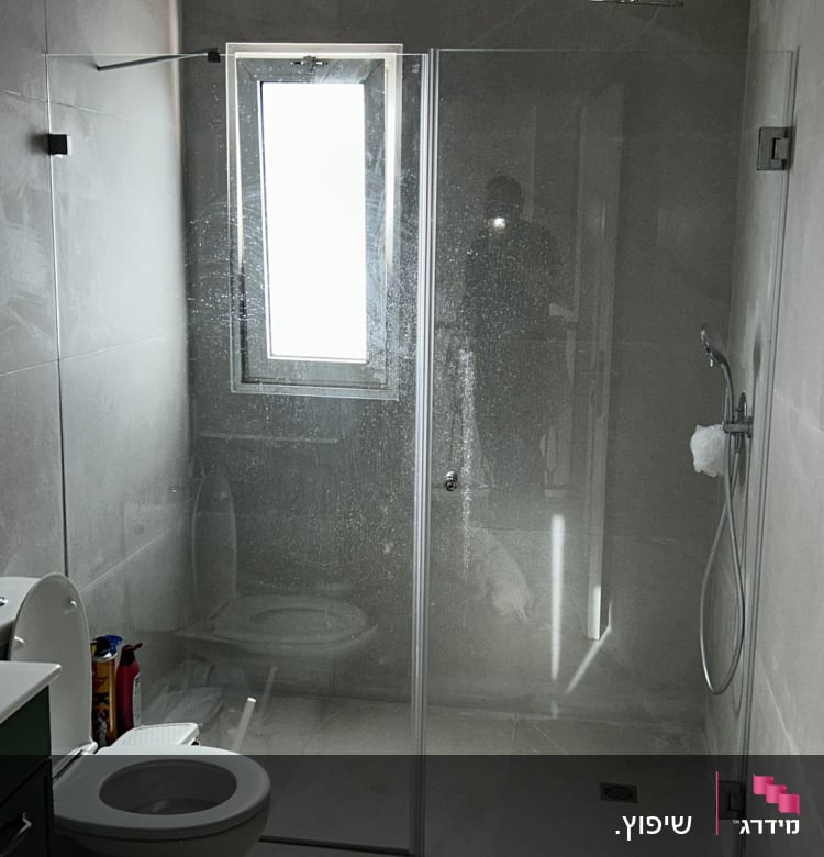 מקלחון זכוכית עם ראש מקלחת, שירותים וחומרי ניקוי