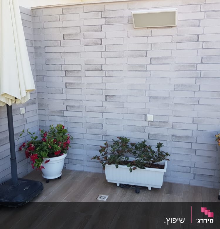 קיר לבנים אפור עם תאורה עליונה