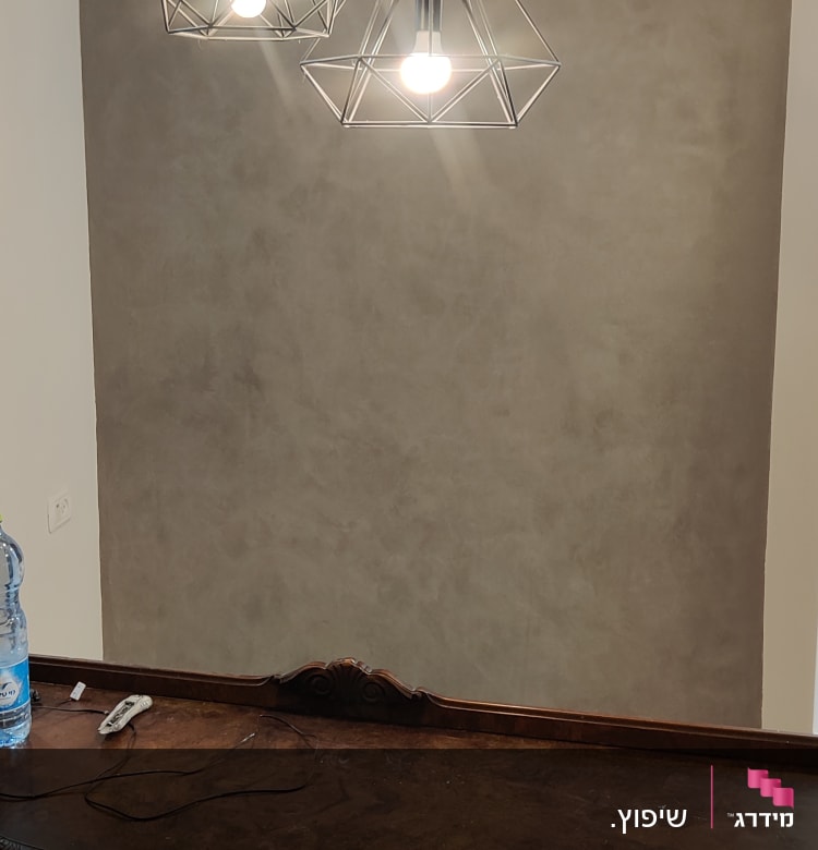 מנורות תלויות מעל קיר בטון חלק