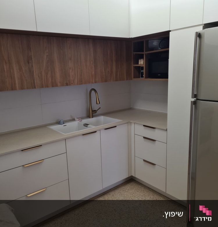 מטבח משופץ עם ארונות לבנים וברז זהב