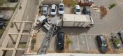 מבט על של משאית הובלה ומנוף הרמה מתוח בבניין מגורים
