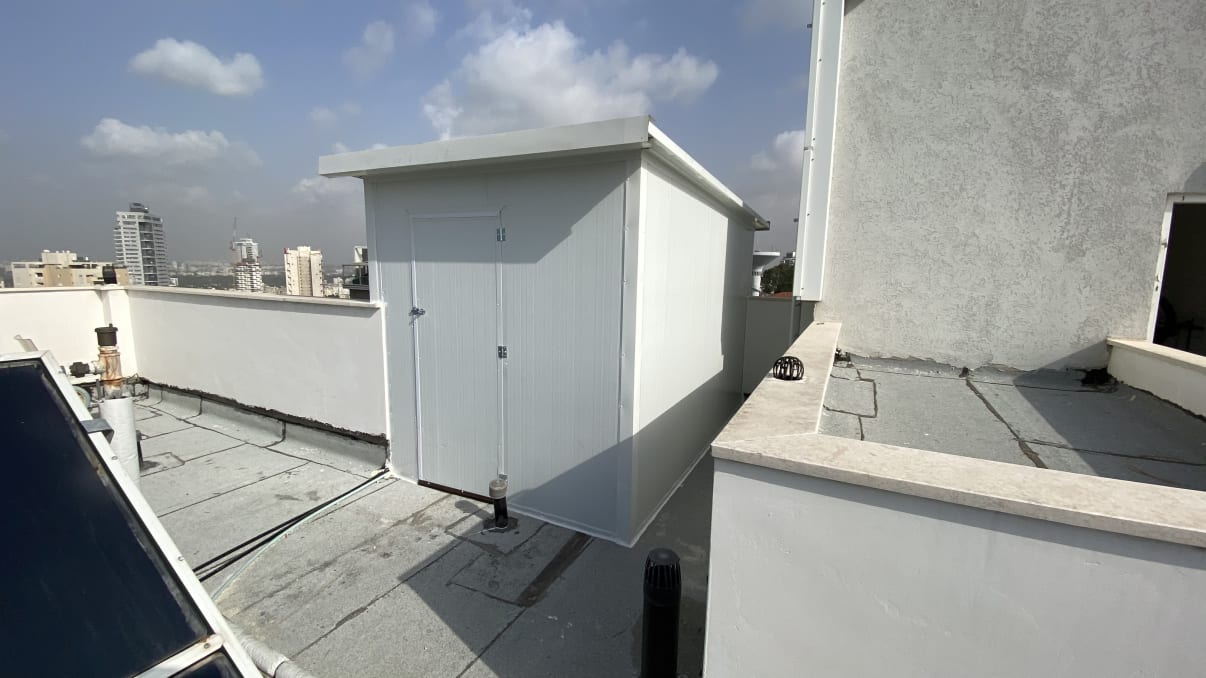 מבנה עץ קטן על גג עם דלת סגורה