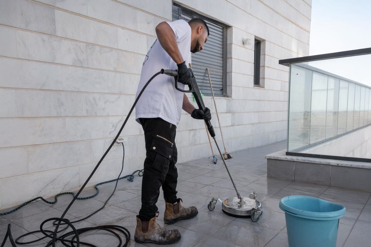 אדם מנקה רצפה עם מכונת שטיפה בלחץ מים אדם מנקה רצפה עם מכונת שטיפה בלחץ מים