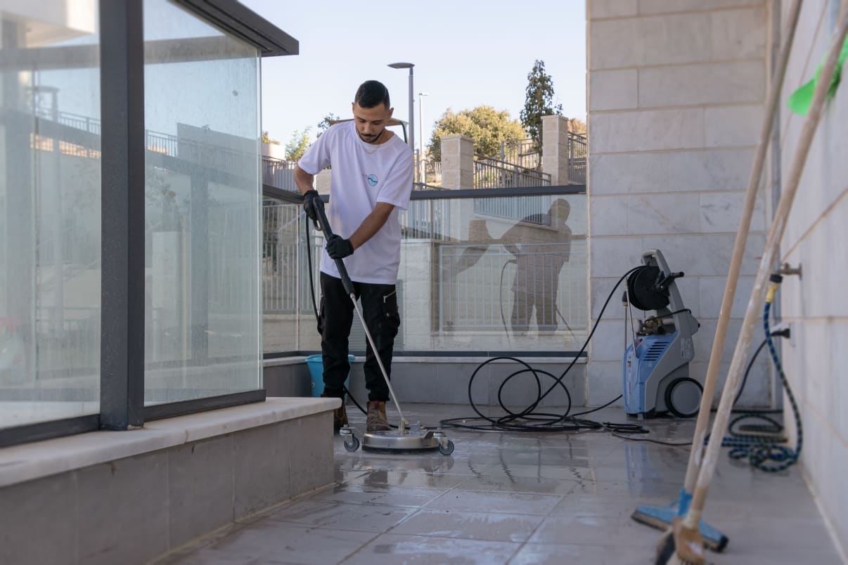 אדם מנקה רצפה עם מכונת שטיפה בלחץ אדם מנקה רצפה עם מכונת שטיפה בלחץ
