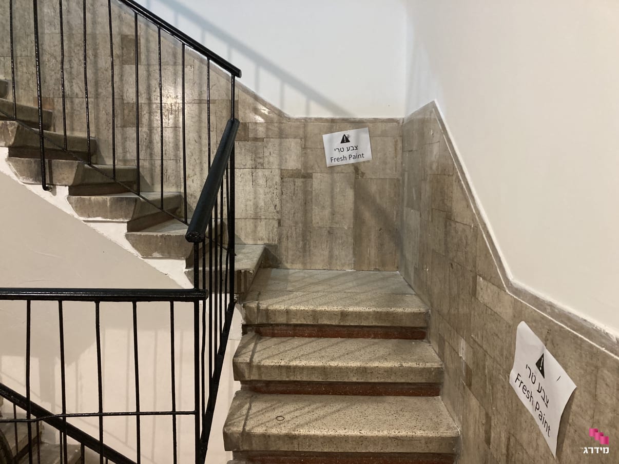 ייבוש של מעקה לאחר צביעה בחדר מדרגות ייבוש של מעקה לאחר צביעה בחדר מדרגות