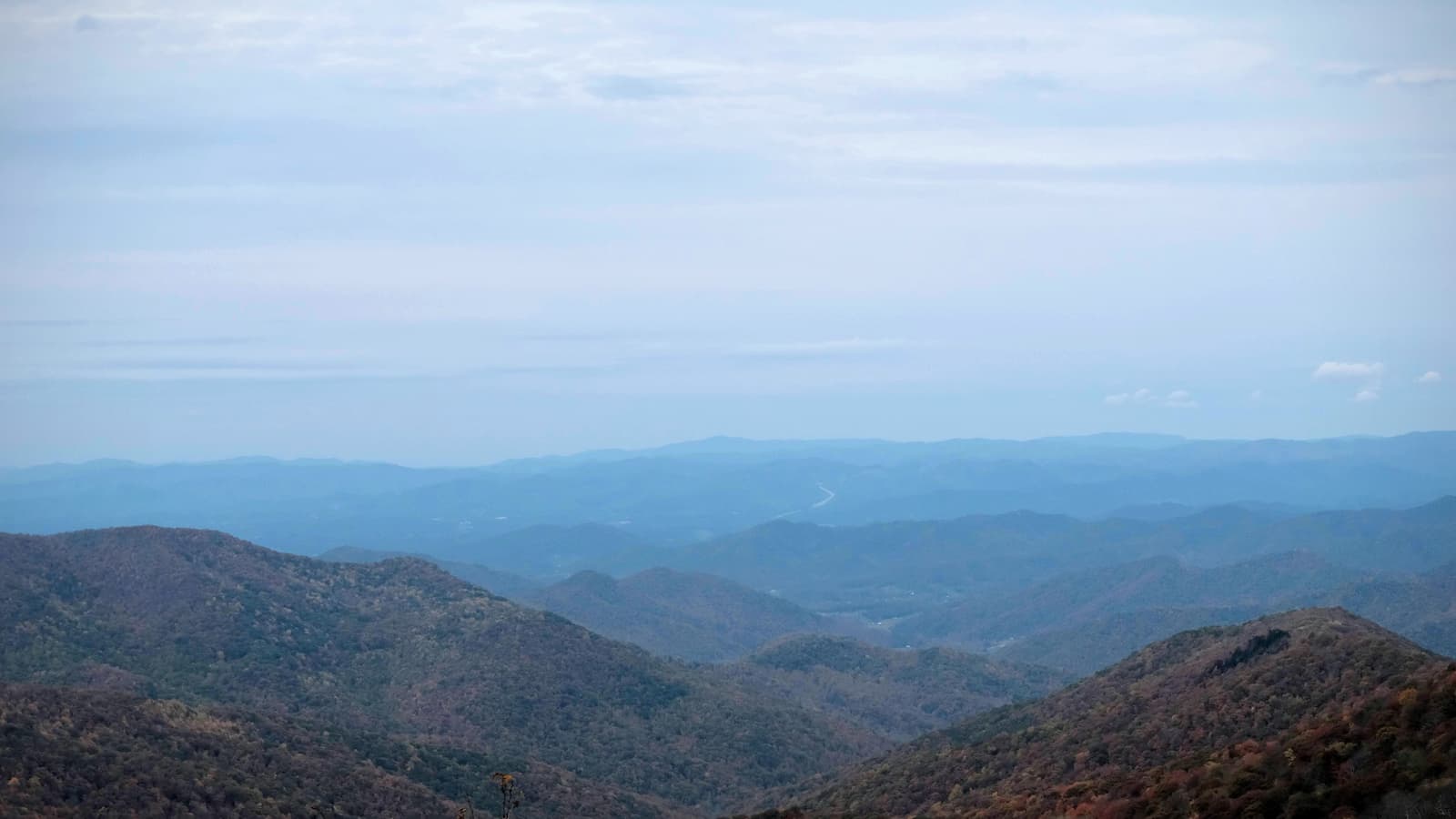 A photo of a vast mountain landscape, showing blue-colored mountain tops extending into the distance