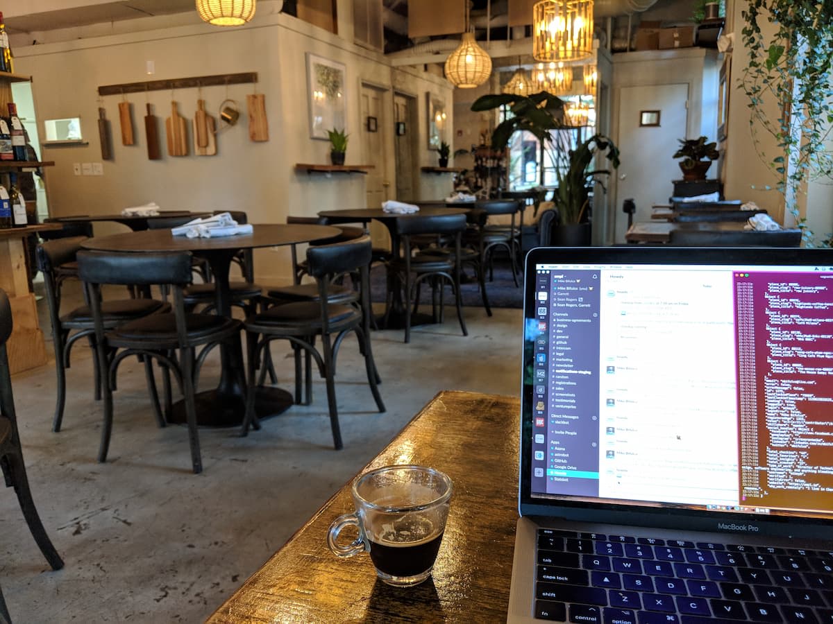 A laptop sitting on a table at a coffee shop