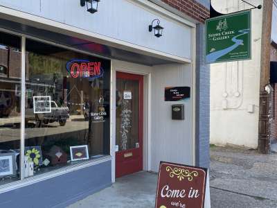 Older brick front building.   There are  beautiful colors  stained glass, and a fairy garden on display in the front window