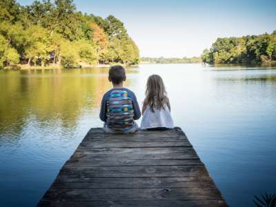 Make lifetime memories at Lake Charles State Park (two kids sitting on pier at lake)