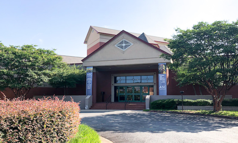 The front of the Arts & Science Center for Southeast Arkansas is shown on a sunny day with manicured landscaping. 