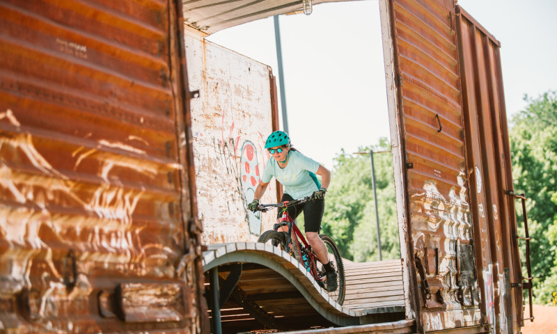 Rider rides through the railcar at The Railyard Bike Park in Rogers, Arkansas