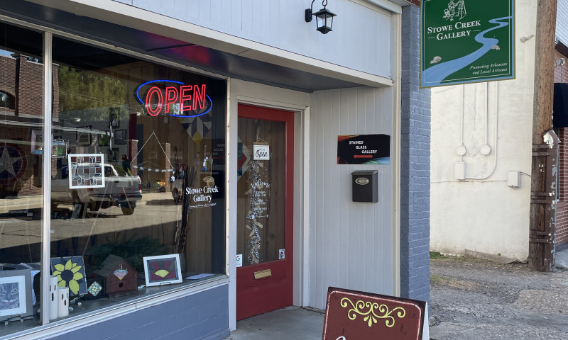 Older brick front building.   There are  beautiful colors  stained glass, and a fairy garden on display in the front window