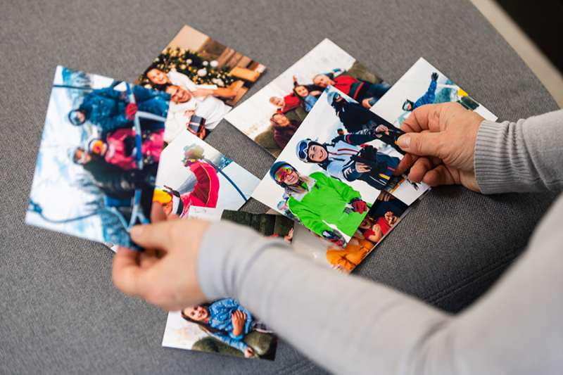 An elderly woman is looking at a photo of her grandkids