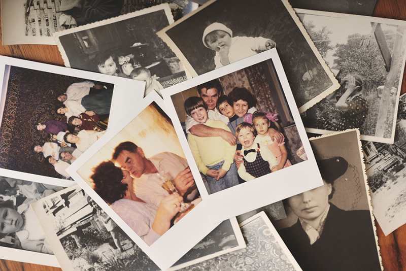 Pile of family photographs on table overhead view