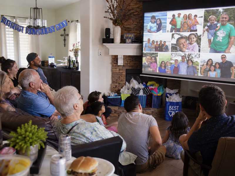 A family watches a Father's Day slideshow at their home