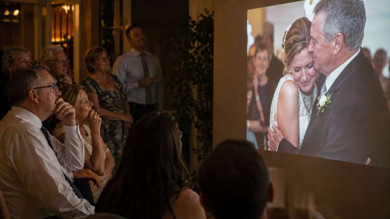 Family watching an anniversary slideshow together