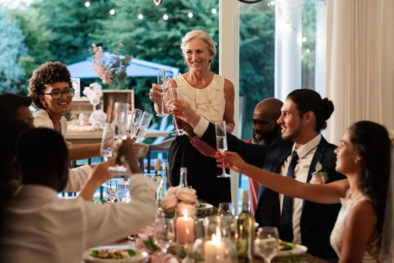 Guests raising glasses in joyful toast at elegant wedding reception
