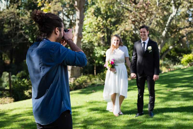 Wedding photographer shooting in an urban park