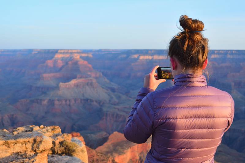 Woman taking photo of Grand Canyon with mobile phone