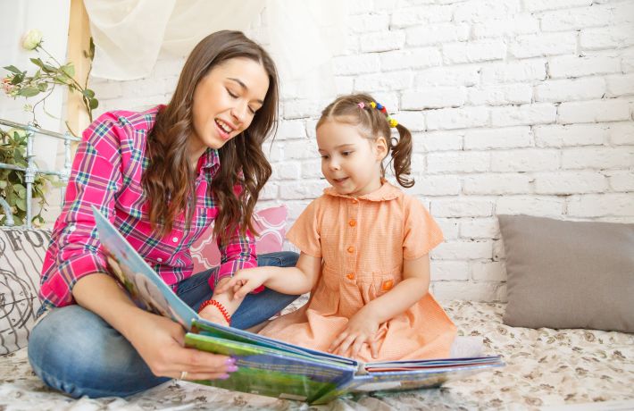 Young mother and her child girl reading a book. Young mother and her child girl reading a book.