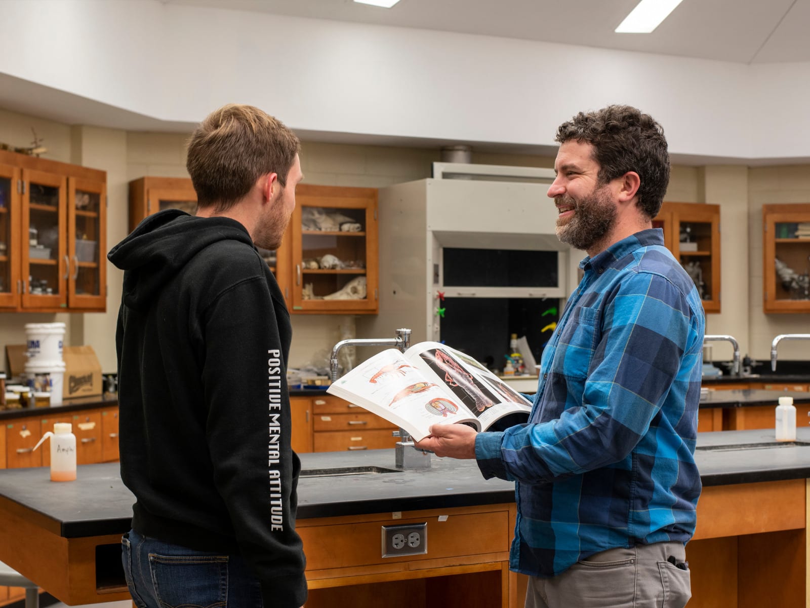 A student and professor talking after class in a science laboratory