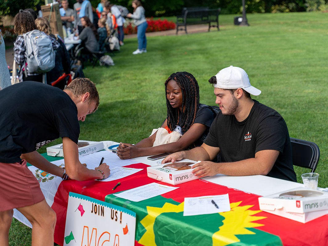students sit at table during rush day 2022