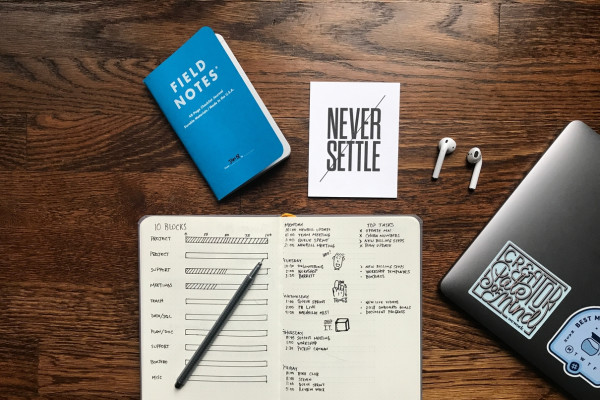 Photo of a desk with an open notebook that has text and diagrams in it