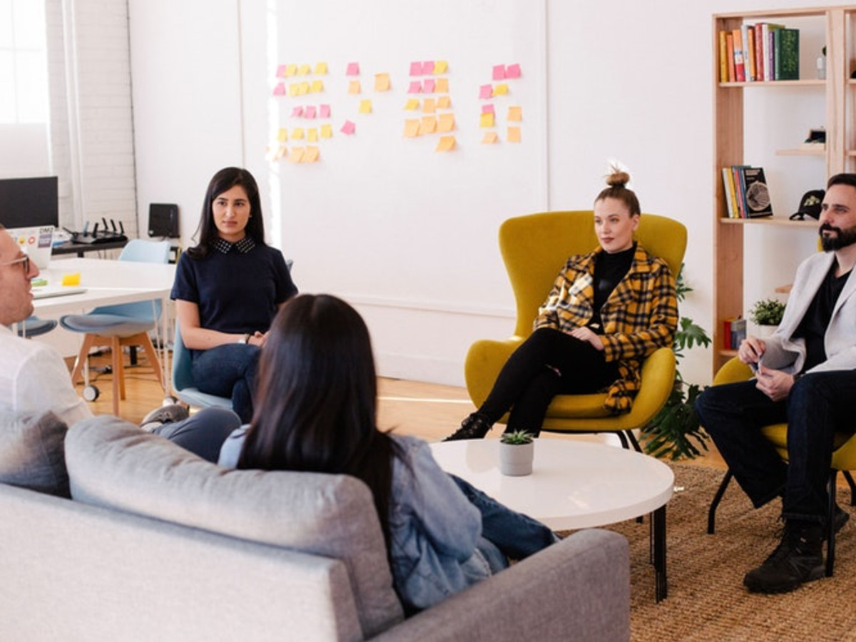 Photo of five people sitting around a table in an office break area