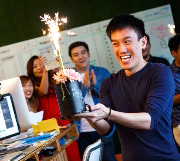 Employees celebrating a colleagues' birthday with a cake