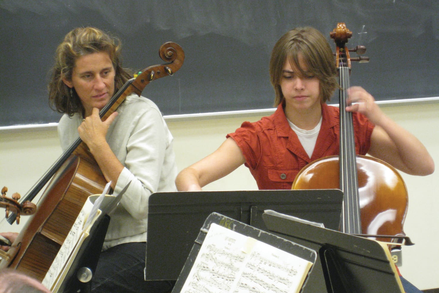Minnesota Orchestra cellist Katja Linfield seated next to a student cellist at Bemidji State University.