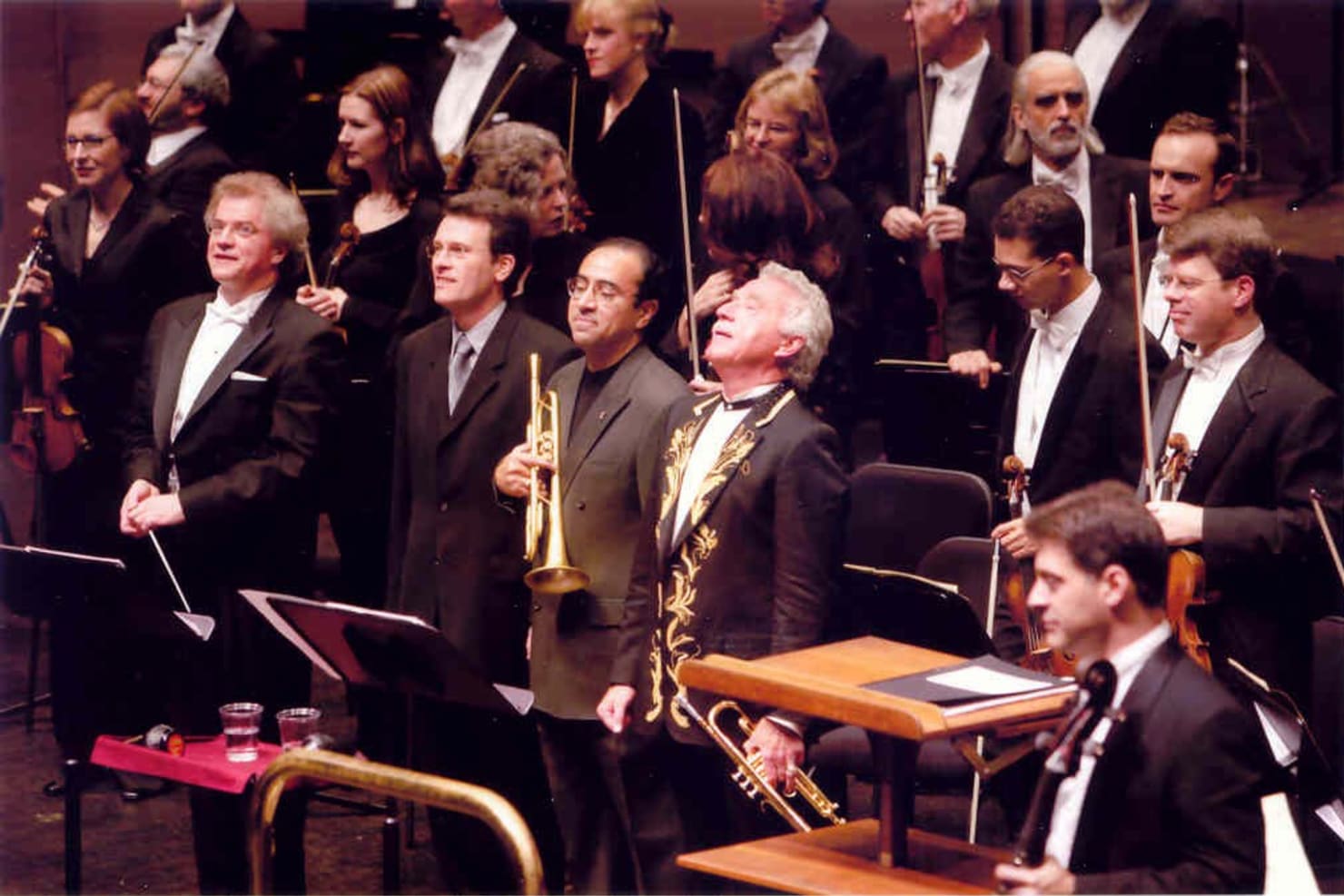 Musicians, the conductor, the composer and two soloists standing to accept applause at Orchestra Hall.