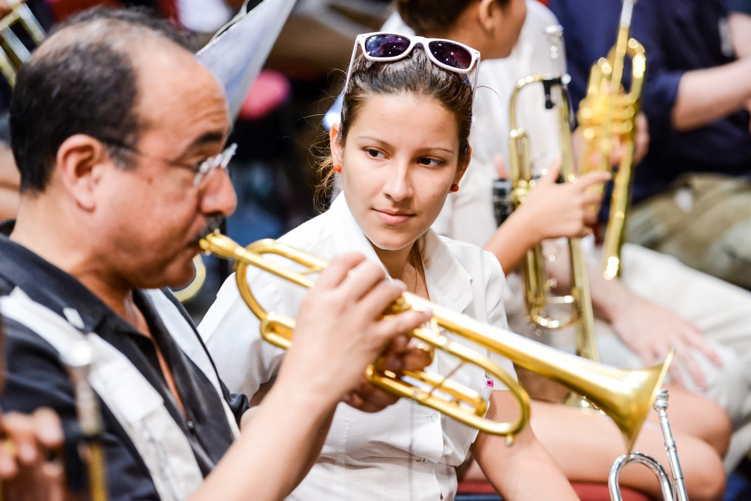 Manny Laureano plays the trumpet as a student musician looks on during the Minnesota Orchestra's Cuba tour in 2015.