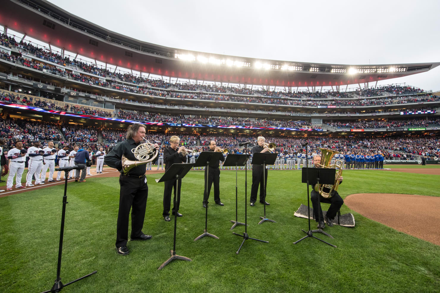 Five brass musicians performing the National Anthem on the field at the Minnesota Twins home stadium, Target Field.