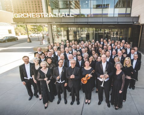 Full Orchestra standing in a group outside of Orchestra Hall