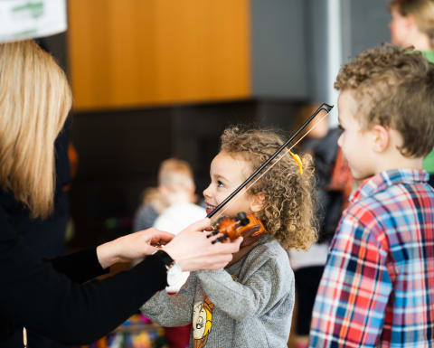 Musician teaching child how to play violin