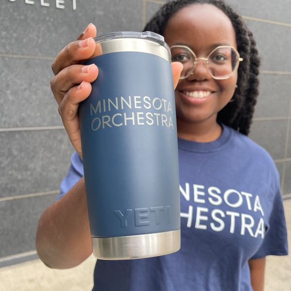 Olivia Hamilton holding a Navy Yeti tumbler with Minnesota Orchestra logo