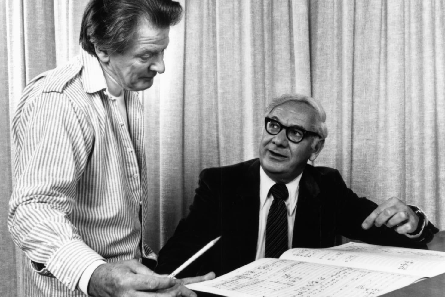 Neville Marriner and Dominick Argento talking in front of sheet music