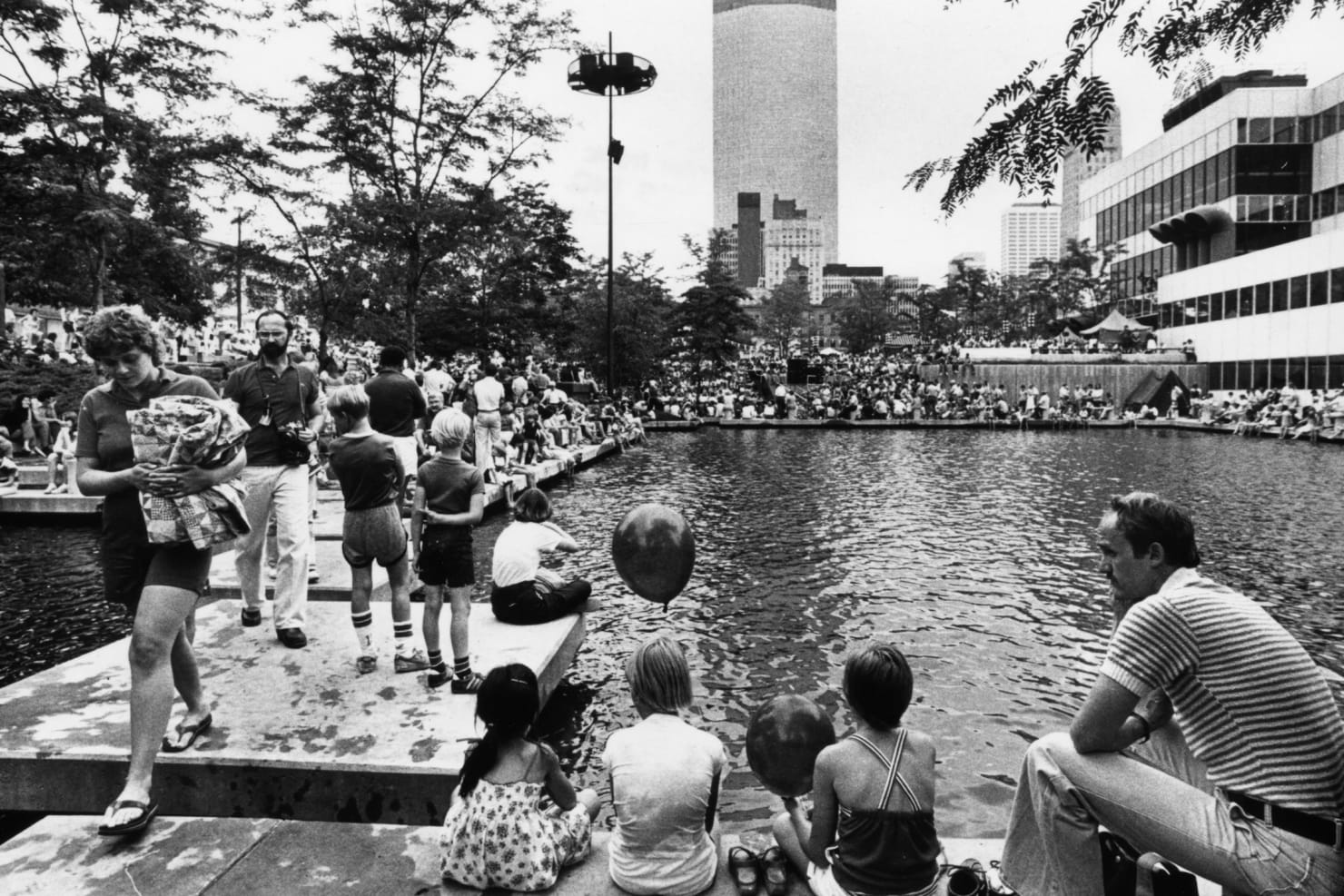 Group of people enjoying sunshine outside of Orchestra Hall in 1980